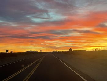 Empty road against orange sky
