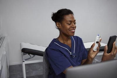 Female doctor having online consultation on smart phone