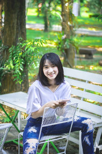 Portrait of a smiling young woman sitting on seat