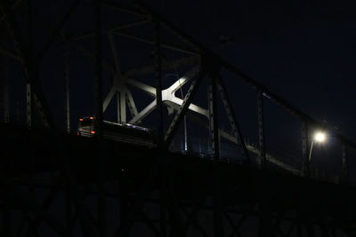 Low angle view of illuminated bridge against sky at night