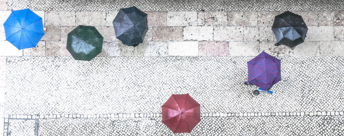 Low section of man with umbrella on street