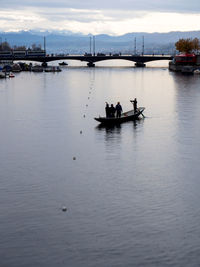 People in boat on river against sky