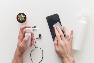 Midsection of man using smart phone against white background