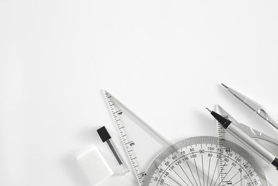 Close-up of set square with protractor on white background