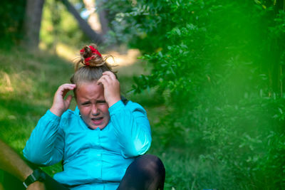 Portrait of man sitting against green plants