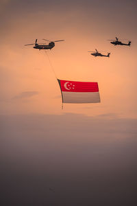 Low angle view of airplane flying against sky during sunset