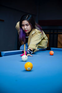 Portrait of woman playing pool