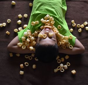 High angle view of boy with snacks on the mat