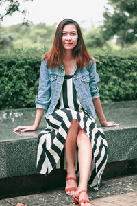 Portrait of young woman sitting outdoors