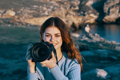 Portrait of young woman photographing