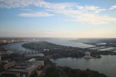 High angle view of cityscape by sea against sky