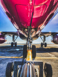 Close-up of airplane in airport runway against sky