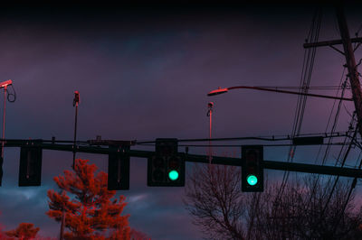 Low angle view of road signal against sky at dusk