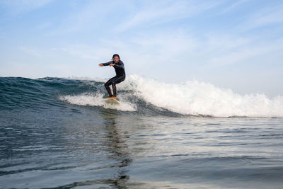 Man surfing on sea against sky