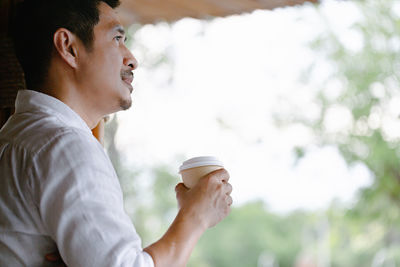 Side view of young man drinking coffee