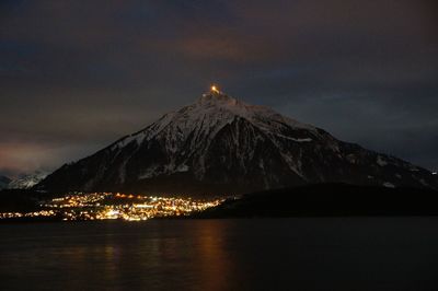 Scenic view of lake thun and snowcapped mountain at night