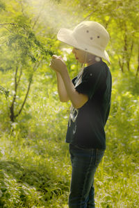 Side view of man wearing hat standing on field