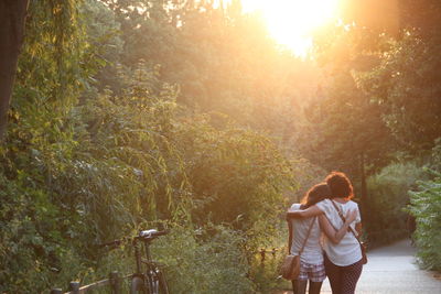 Rear view of lesbian couple walking amidst trees