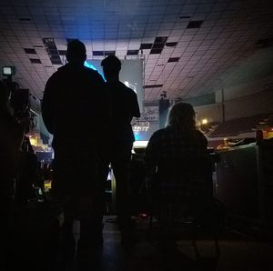 Rear view of silhouette man standing in illuminated city