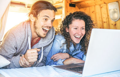 Happy couple using laptop in motor home