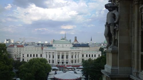 Buildings in city against cloudy sky