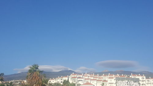 Panoramic view of city against clear blue sky