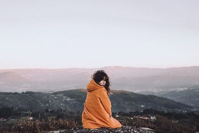 Woman standing on mountain against clear sky