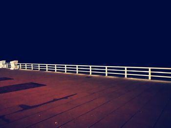 Footpath by railing against sky