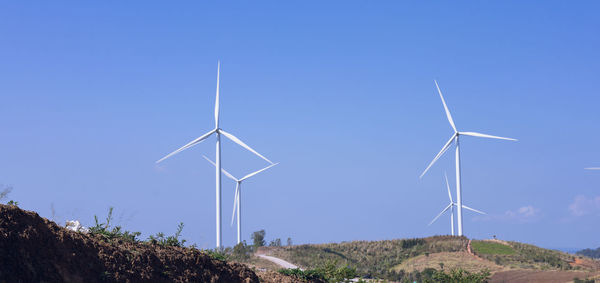 Low angle view of windmill against clear blue sky