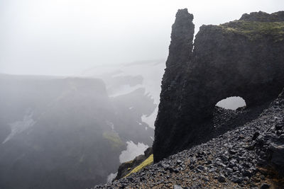 Rocky volcanic hills on a cloudy stormy day while hiking iceland