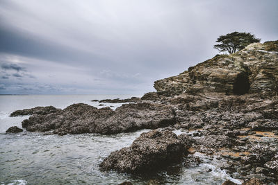 Rock formations by sea against sky