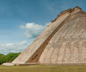 Low angle view of old ruin building against cloudy sky