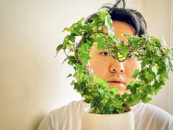 Portrait of man with green leaves