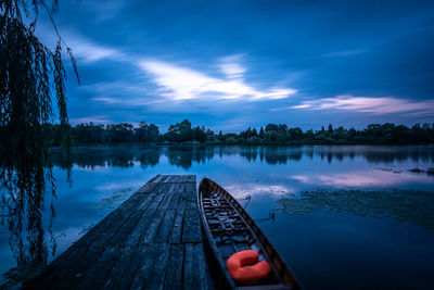 Pier over lake against sky at dusk