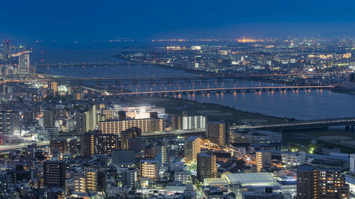 Illuminated cityscape against sky at night