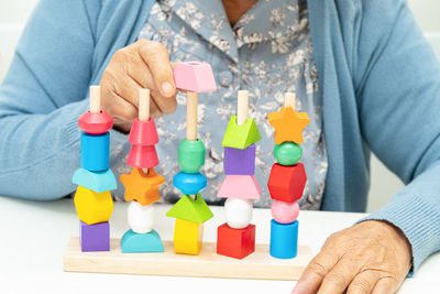 Midsection of woman playing with toy blocks on table