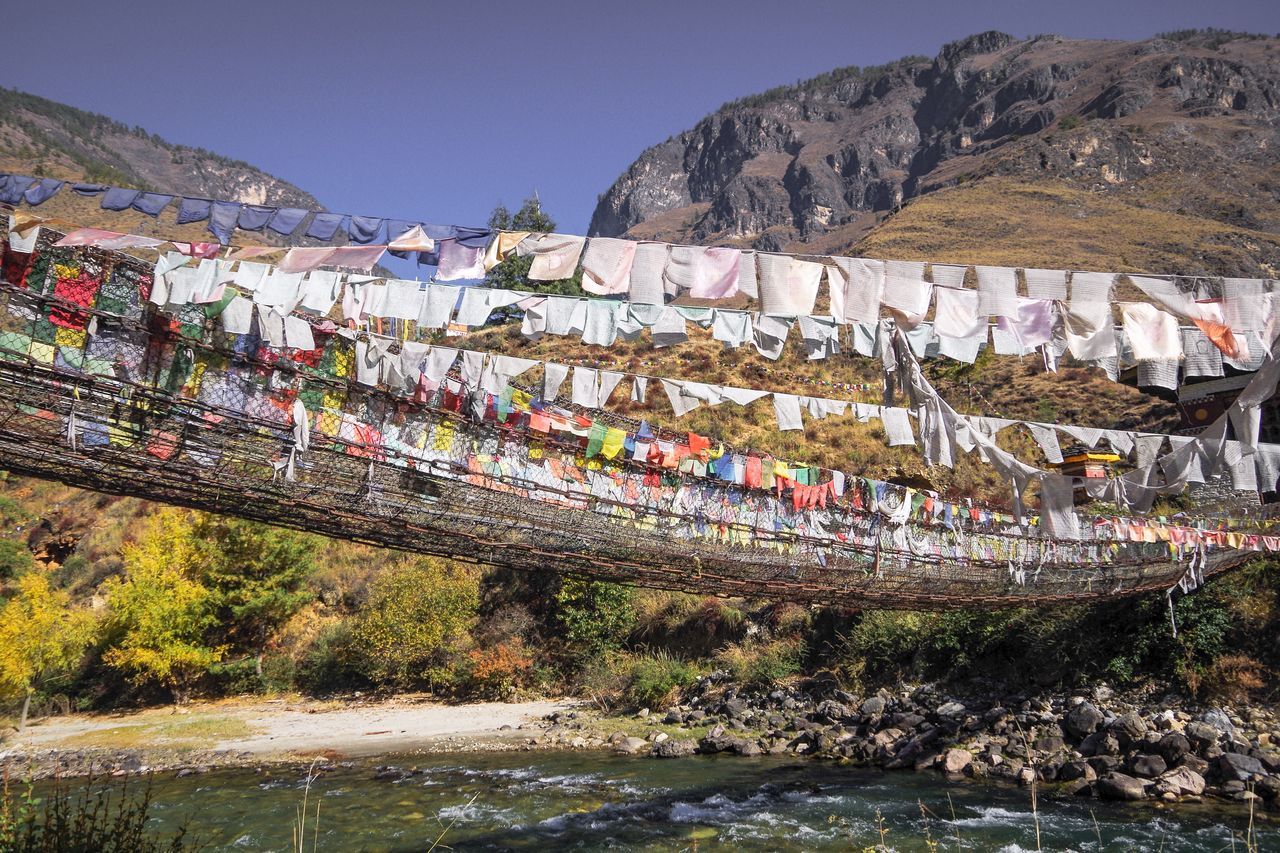 multi colored, railing, sky, outdoors, no people, day, mountain, beauty in nature, water, flag