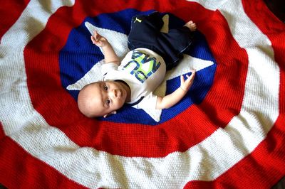 High angle view of cute baby lying on bed