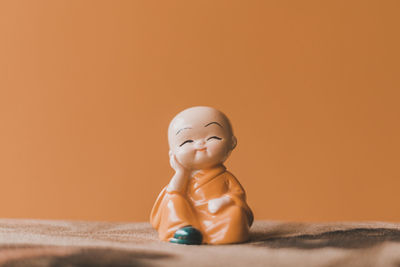 Close-up of figurine against yellow background