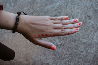 Close-up of woman hand on red surface