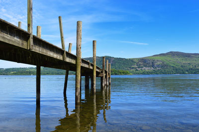 Wooden bridge over river against sky