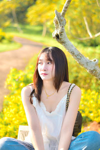 Portrait of young woman sitting on field