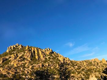 Low angle view of rock formations against blue sky