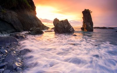 Rock formation on sea against sky during sunset