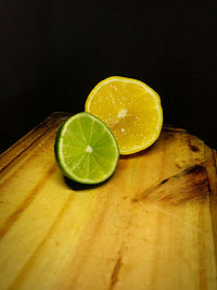 Close-up of lemon and lime slices on table wood