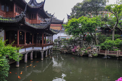 Built structure by lake and trees against sky