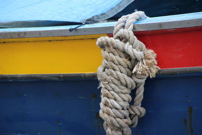 Close-up of rope tied to boat moored at harbor