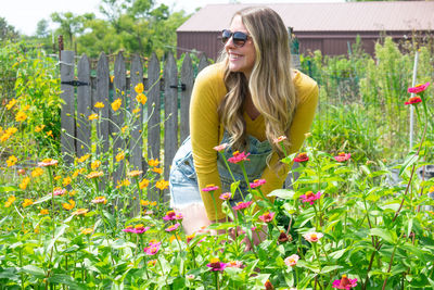 Young woman wearing sunglasses on red flowering plants