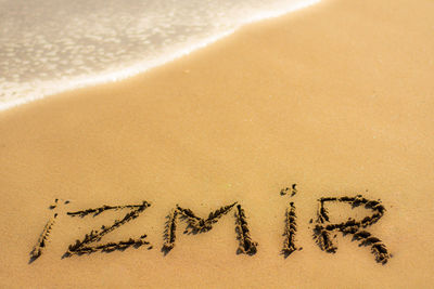 High angle view of izmir text on sand