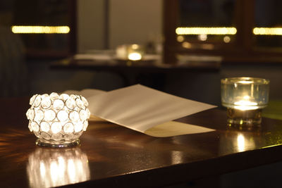 Close-up of illuminated tea light candles on table